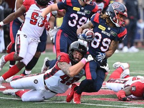 Alouettes' James Letcher Jr. is tackled by Redblacks' Anthony Gosselin during a game this month.