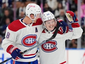 Canadiens defenceman Mike Matheson, left, is seen congratulating COle Caufield after the latter scored a goal.
