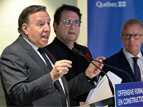 Quebec Premier François Legault makes an announcement alongside Education Minister Bernard Drainville and Labour Minister Jean Boulet.