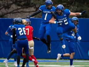 Montreal Carabins Kaylyn St-Cyr (1) celebrates with Alexandre Levac (75) his first half interception against the Laval Rouge et Or in USports Dunsmore Cup university football action in Montreal on Saturday, Nov. 11, 2023.