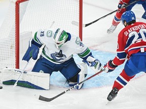 Canucks goalie sticks out his right pad to stop a shot in clsoe by Canadiens' Juraj Slafkovsky.
