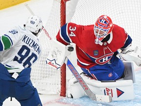 Canadiens goaltender Jake Allen stops Vancouver Canucks' Andrei Kuzmenko (96) during second period NHL hockey action in Montreal on Sunday, Nov. 12, 2023.