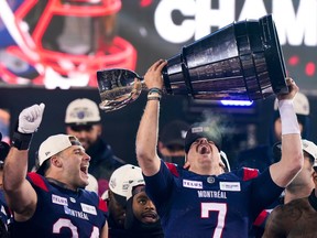 Montreal Alouettes quarterback Cody Fajardo (7) hoists the Grey Cup as fullback Alexandre Gagne (34) looks on as the Alouettes celebrate defeating the Winnipeg Blue Bombers in the 110th CFL Grey Cup in Hamilton, Ont., on Sunday, Nov. 19, 2023.
