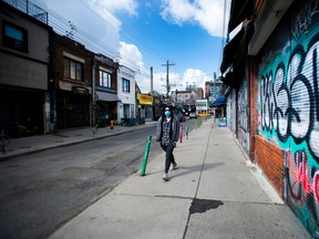 A person walks past closed businesses in Toronto, on April 15, 2020.