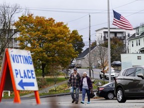 Voter arrive at a polling place at the Gov. James B. Longley Campus, Tuesday, Nov. 7, 2023, in Lewiston, Maine. The American flag still flies at half mast in honor of the 18 people who were killed in mass shootings less than two weeks ago.