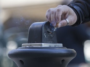A man stubs out a cigarette in a public ashtray in Paris, France, on Oct. 1, 2015.
