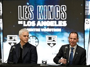 Quebec Finance Minister Eric Girard speaks at a news conference Tuesday, November 14, 2023 at Centre Vidéotron in Quebec City. Luc Robitaille, president of the Los Angeles Kings, looks on.