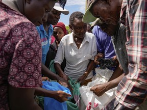 Residents receive relief food after El Niño rains damaged their houses in Bangale town in Tana River county, Kenya, on Sunday, Nov. 26, 2023.