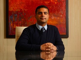 Darshan Daryanani sits at a boardroom table posing for a photo