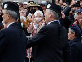 Crowds applaud the veterans marching for Remembrance Day at the National War Memorial in Ottawa, Nov. 11, 2022.