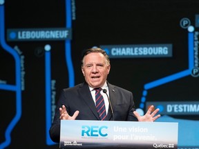 François Legault gestures from a podium