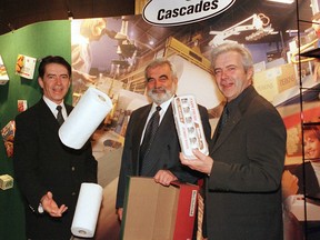 Three men are holding paper products including paper towels and an egg carton.