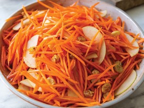 A carrot and apple salad in a white bowl.