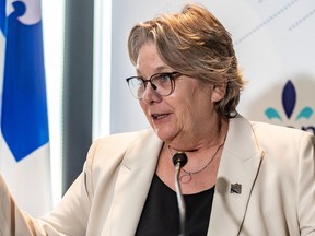 Chantal Rouleau at a podium during a news conference with a Quebec flag behind her