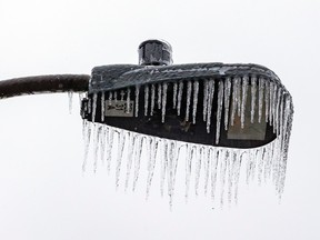 Closeup of a streetlight with icicles.