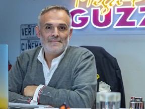 Vincenzo Guzzo looks at the camera seated at a desk in an office