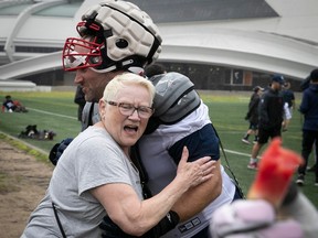 Lifelong Alouettes fan Heather Lowengren gives a hug to Alouettes guard Kristian Matte after a practice last July.