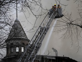Firefighters on a crane work to extinguish a major blaze in an Old Montreal building.