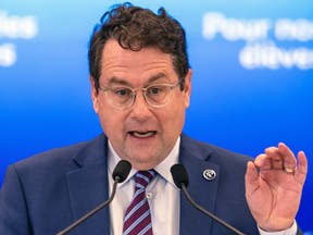 Bernard Drainville speaks into microphones during a news conference