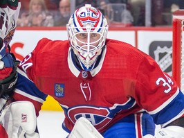 canadiens goalie jake allen is seen in a close-up peering out from his net.