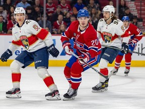 Canadiens' Juraj Slafkovsky is seen between two Panthers players with his eyes following the play last week at the Bell Centre.