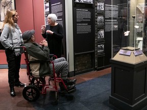 Three people gather in a museum exhibit