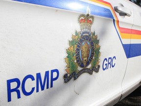 Photo of the side of an RCMP vehicle with a decal and the letters 'RCMP' and 'GRC' on either side of said decal.