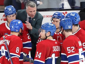 Canadiens head coach Martin St Louis speaks to his players gathered around him in a semi-circle.