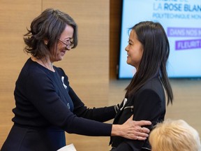 Two women embrace at an awards ceremony.