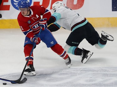 Brendan Gallagher with the puck on his stick as a Kraken player falls behind him