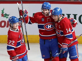 Canadiens' Sean Monahan celebrates his power-play goal against the Kraken, flanked by teammates Cole Caufield, left, and Nick Suzuki at the Bell Centre on Monday.