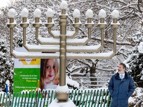 Jeremy Levi stands beside a large menorah in the snow