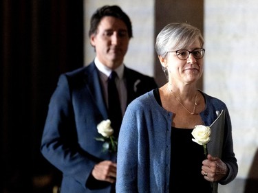 Geneviève Bergeron and Justin Trudeau stand holding white roses