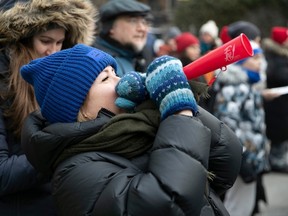 A woman blows into a horn during a protest in support of striking teachers.