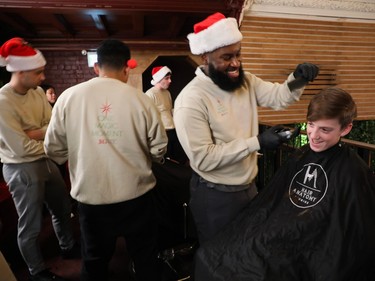 Rhys Russell gets his hair cut by Chris Montina at an event called One Magic Moment in Montreal on Sunday, Dec. 17, 2023.