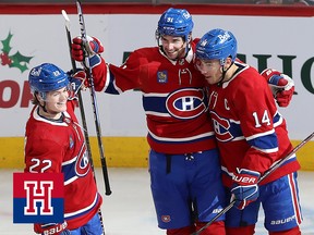 Three hockey players celebrate a goal