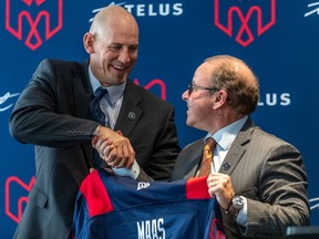 Alouettes general manager Danny Maciocia, right, shakes the hand of coach Jason Maas exactly one year ago when he was first hired.