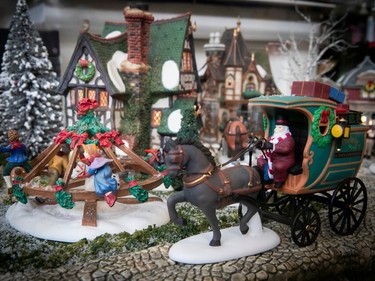 A miniature horse and cart is part of a Christmas village.