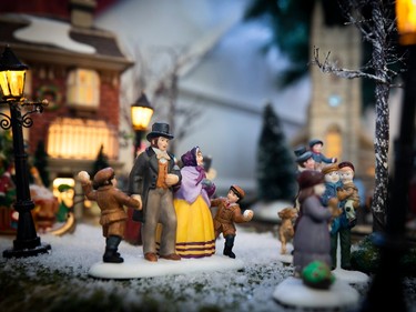 A tiny family in a miniature Christmas village.
