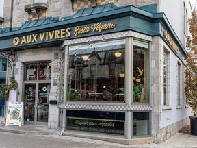 A restaurant storefront is seen in this image. There's a large window and a sign above it that says AUX VIVRES in gold letters.