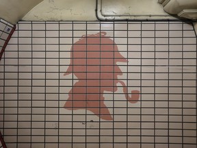 A silhouette of Sherlock Holmes in red on a white metro tile background.