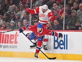 Detroit Red Wings' Robby Fabbri (14) jumps as Canadiens Mike Matheson (8) delivers a hit during the first period at the Bell Centre on Saturday, Dec. 2, 2023, in Montreal.