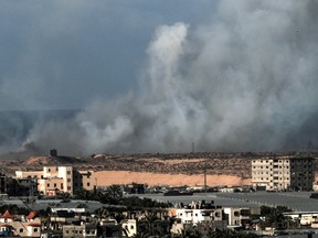 Smoke billows next to tents of displaced Palestinians in the Al-Mawasi area.