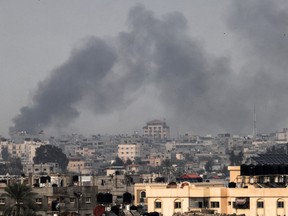 A picture taken from Rafah shows smoke billowing during an Israeli strike over Khan Yunis.