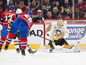 Canadiens' David Savard can be seen from behind as he fires a shot past Penguins goaltender Alex Nedeljkovic on the right side of the net for a goal.