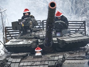 A tank crew wearing Santa hats goes to perform a combat mission. The T-64 battle tank was wrapped in a garland and a crew of tankers in the guise of Saint Nicholas (or Santa Claus) on Sunday, Dec. 24, 2023, in Bakhmut Region, Ukraine.