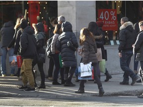 Christmas shoppers walk on Ste-Catherine St. in Montreal.