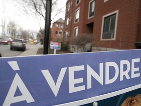 Photo shows À vendre sign outside a condo building in Montreal.