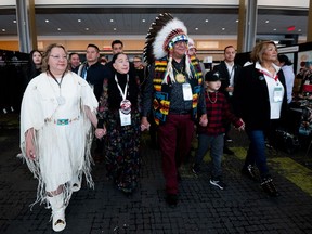 Cindy Woodhouse, left, interim national chief Joanna Bernard, second left, and David Pratt, centre, walk toward the main stage during the third day of the Special Chiefs Assembly in Ottawa, on Thursday, Dec. 7, 2023.