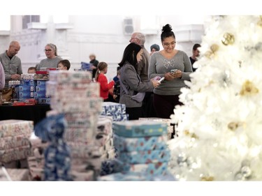 Presents are piled high during the Montreal Community Cares Christmas Gift Wrapping Party, in Montreal, on Sunday, Dec. 3, 2023.